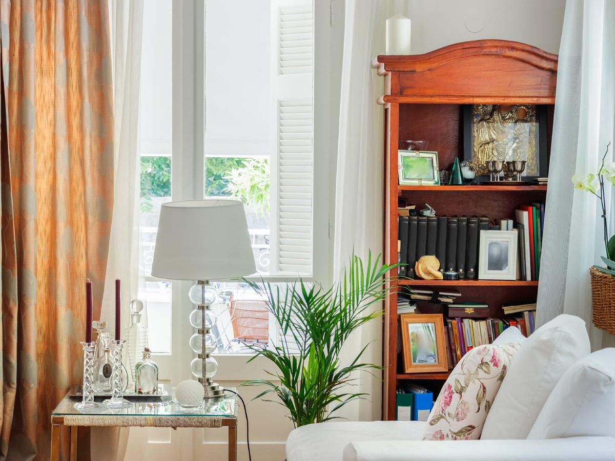 Rincón de lectura con cortinas en un salón.