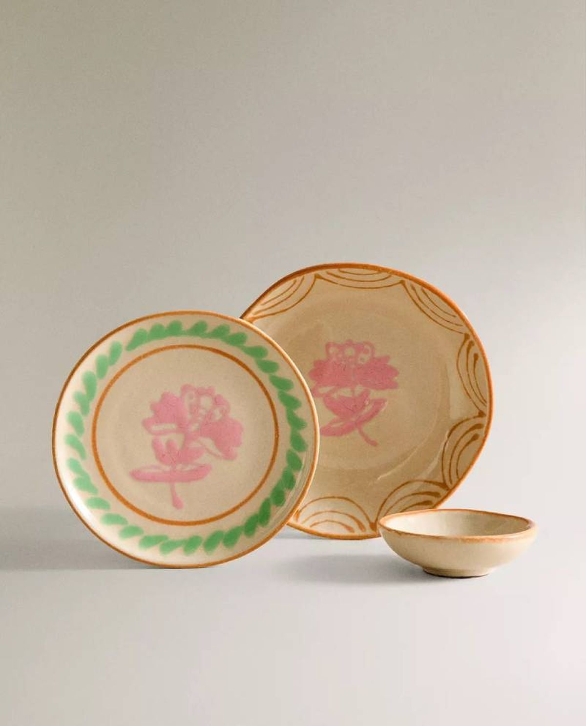 Vajilla beige, rosa y verde Nanushka.