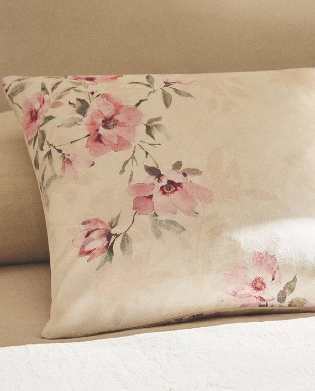 Cojín con flores rosas.
