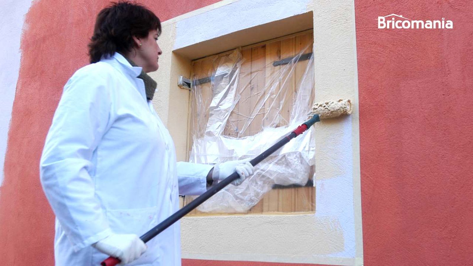 Persona pintando una pared de la fachada