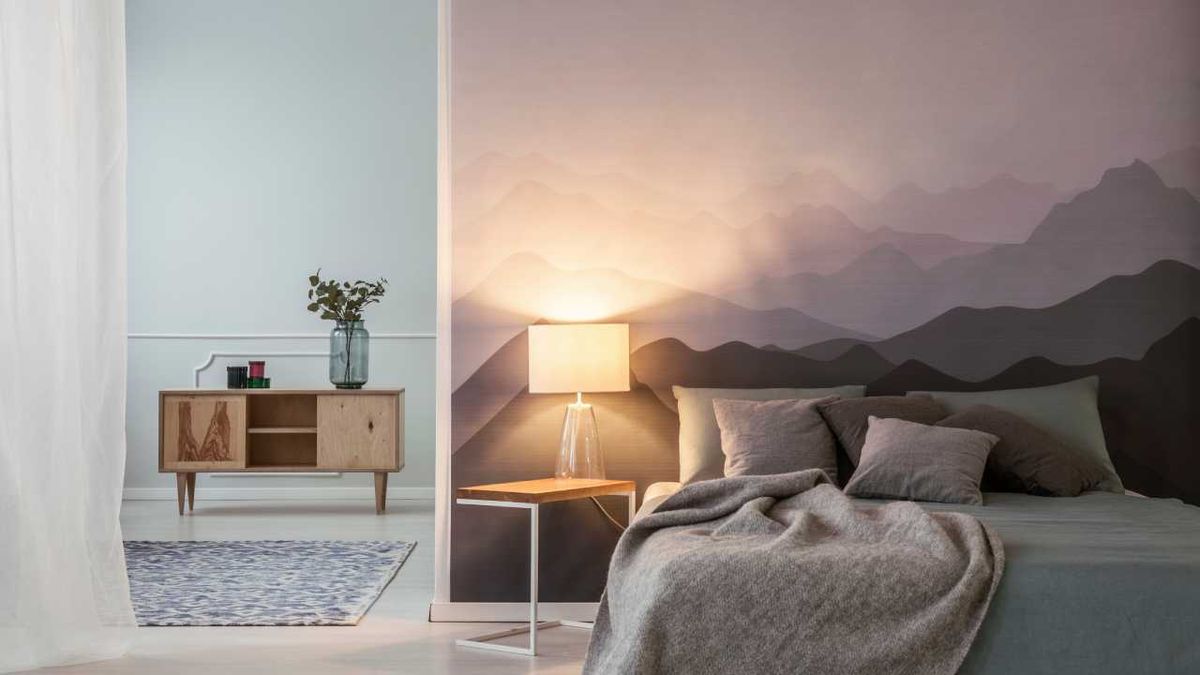 Dormitorio con vinilo de paisaje en la zona del cabecero.