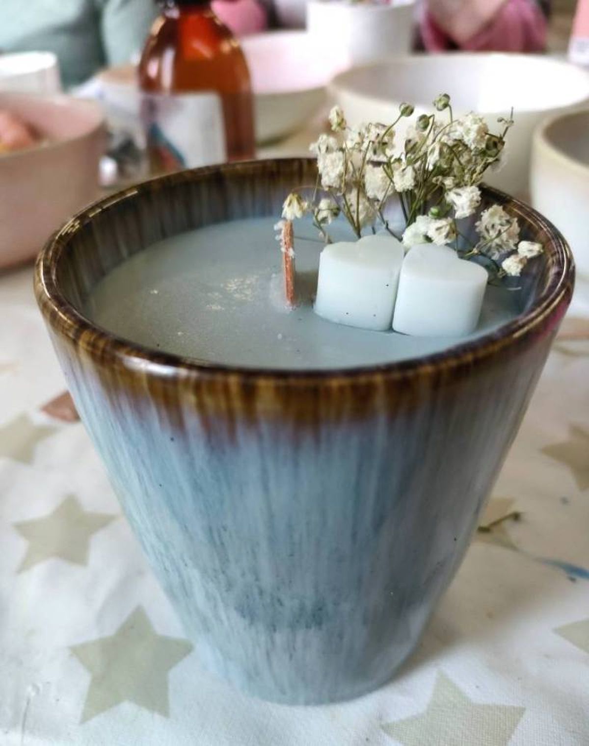 Vela artesanal en color azul con mecha de madera.