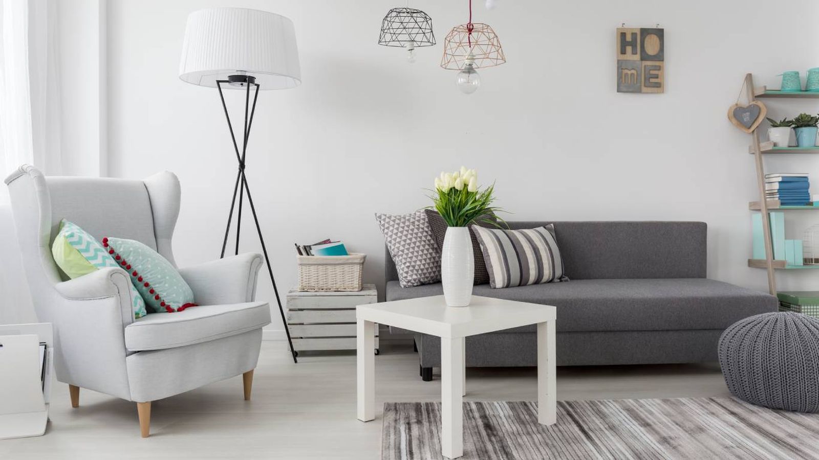 El blanco y gris, junto con la luz natural, hacen que este salón pequeño se perciba más grande y acogedor.