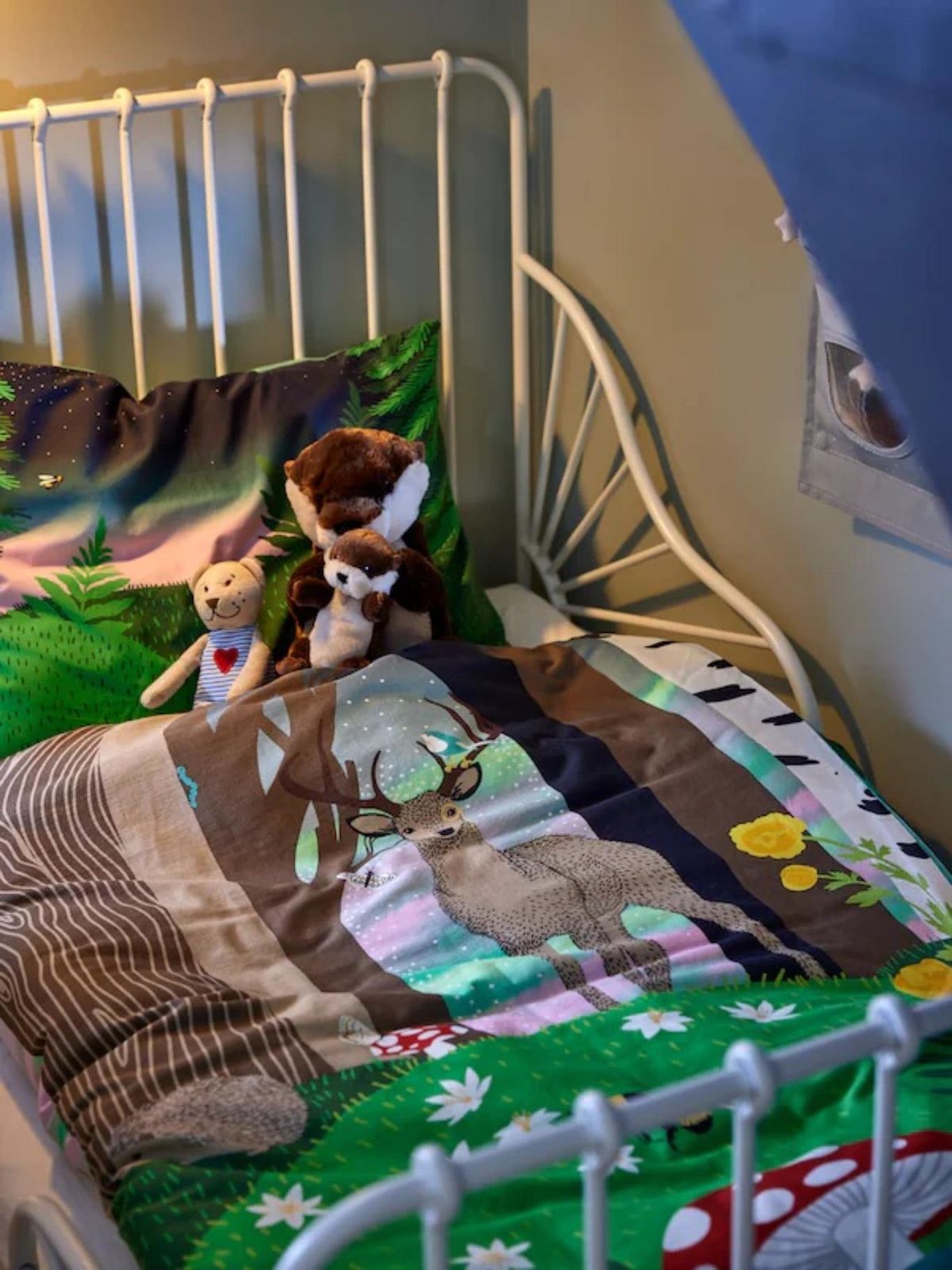 Dormitorio infantil con colcha con estampado de ciervo.