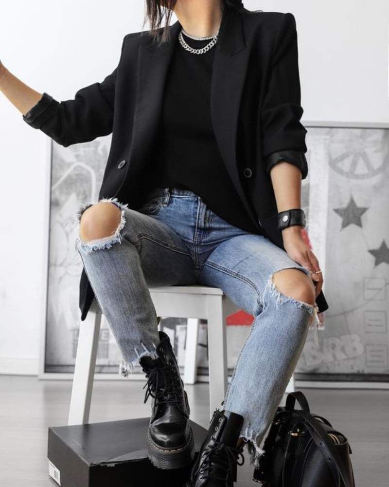 Mujer con vaqueros rotos estilo noventero